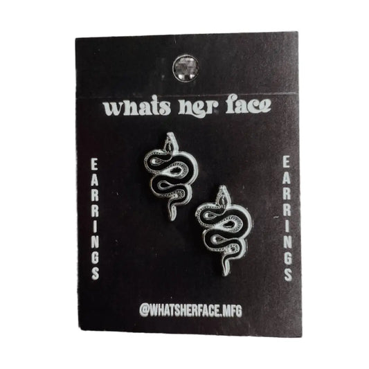 Tiny black and silver hard enamel snake earring studs on cardstock | PABOOM